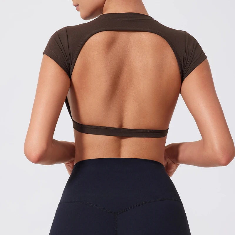 A woman wearing a dark brown women's fitness crop top yoga and gym t-shirt, shown from the back.