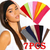 A set of seven solid colored elastic hair bands displayed next to a model's face.