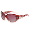 A pair of women's red-tinted polarized sunglasses featuring a white and red patterned frame and diamond-inlaid accents.