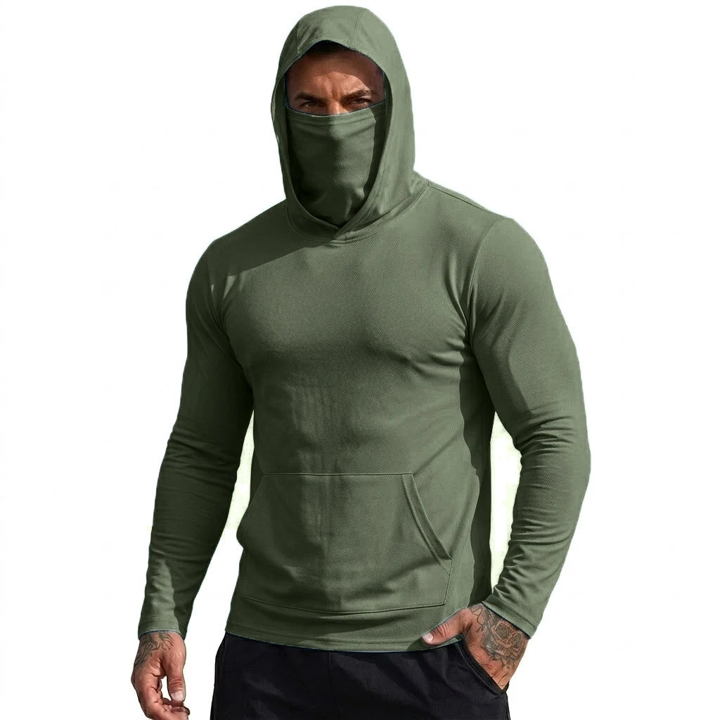 Ein Mann trägt einen olivgrünen Kapuzenpullover mit hochgezogener Kapuze und zeigt sein Gesicht.