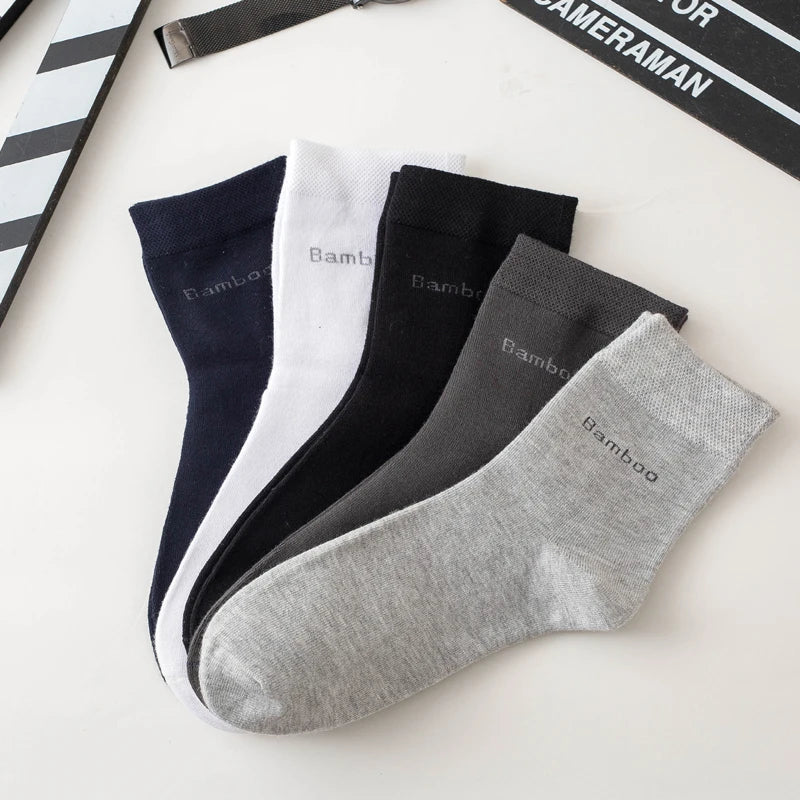 A stack of five men's bamboo fiber socks in various colors including navy, white, black, and gray.