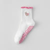 Chaussettes de yoga blanches avec des bords froncés roses et un petit motif animal brodé.