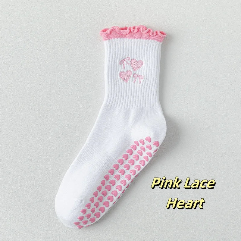Weiße Stricksocken mit rosa Spitzenherzdetails an Zehen und Bündchen.