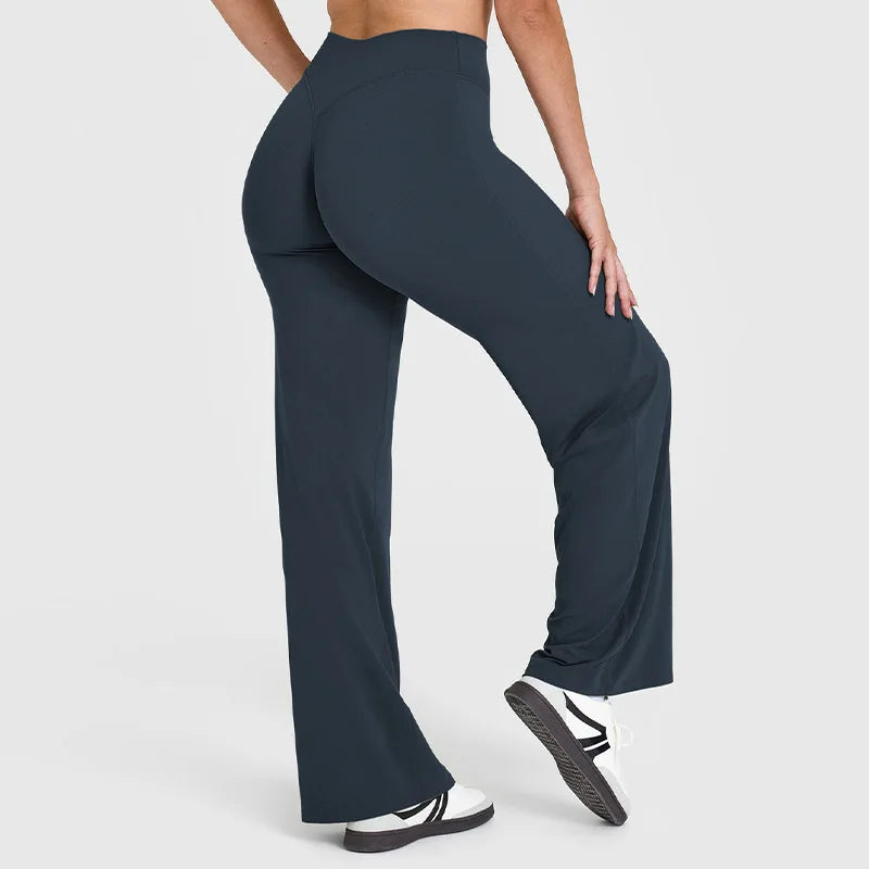 A person wearing dark navy high-waist yoga pants and white sneakers.