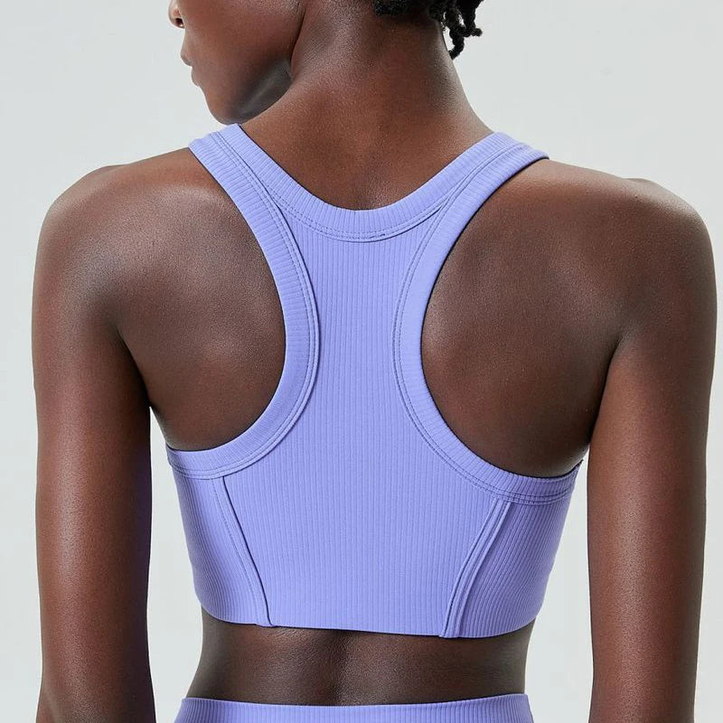 A model wearing a lavender high-impact stretch yoga crop top from the back view.