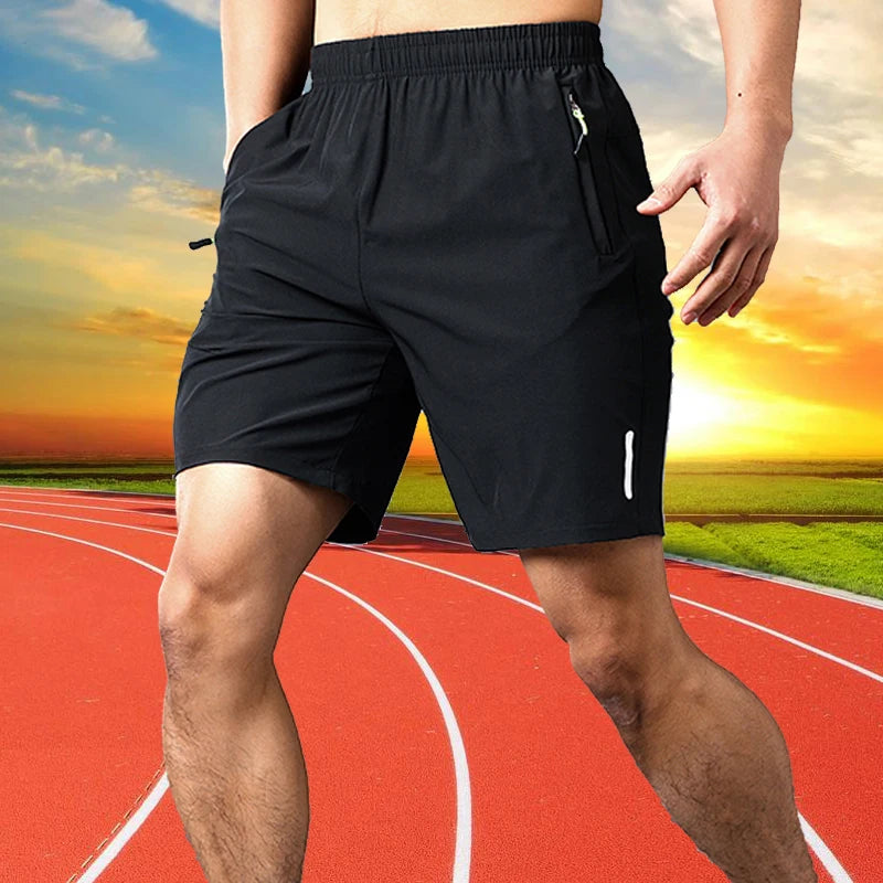 A man wearing black men's quick dry jogging shorts is shown running on a red track.
