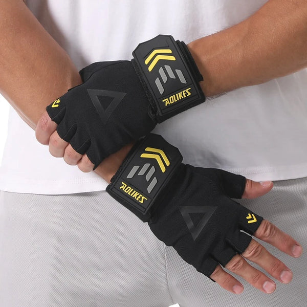 Black weightlifting grips with yellow accents worn on a hand.