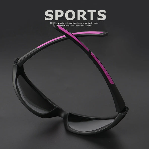 A pair of black sports sunglasses with a pink accent line displayed against a dark background.