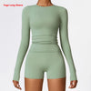 A model wearing a long sleeve sage green yoga and fitness t-shirt with a ruched midsection.