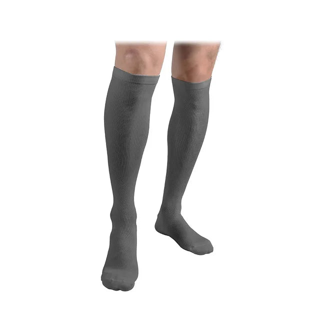 A pair of grey compression socks worn on a person's lower leg.
