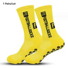 A pair of bright yellow anti-slip performance sports socks shown flat.