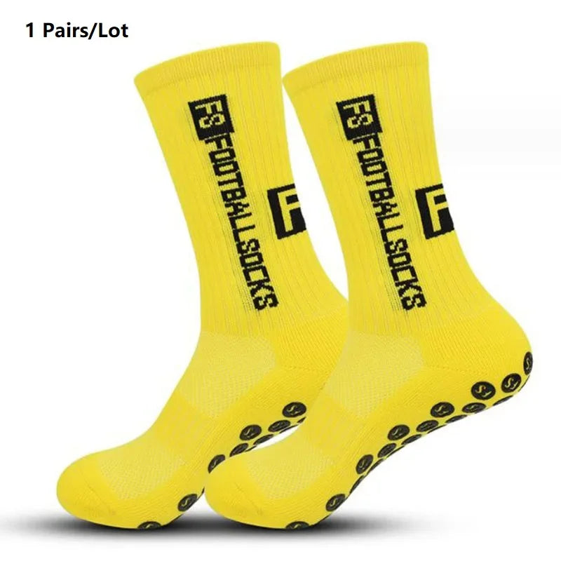 A pair of bright yellow anti-slip performance sports socks shown flat.