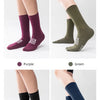 A set of professional cycling and MTB socks in purple, green, and black colors shown on legs.