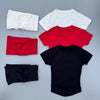Une collection de cinq hauts de yoga et de sport sans coutures en blanc, rouge, noir et bleu marine.