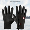 A pair of black windproof gloves shown against a snowy outdoor background.