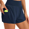 Eine Frau trägt marineblaue, hochgeschnittene Sportshorts mit gelbem Taschendetail.