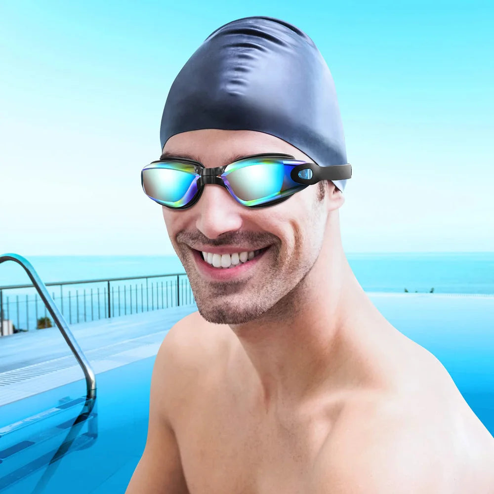 A man wearing professional anti-fog swimming goggles and a black swim cap smiling outdoors.
