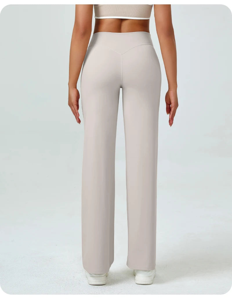 A woman wearing light beige high waisted yoga pants and a cropped top.
