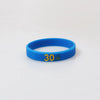 A bright blue silicone wristband with the number 30 printed on it.