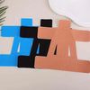 Three colored elastic patches—blue, black, and peach/tan—are laid out on a white surface.