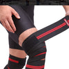A person wearing black compression knee wraps with red stripes on their lower leg.