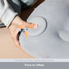 A hand is pressing a button on a gray inflatable pillow designed for neck and lumbar support.