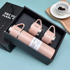 A pink vacuum flask is displayed inside a black box with a wooden background.