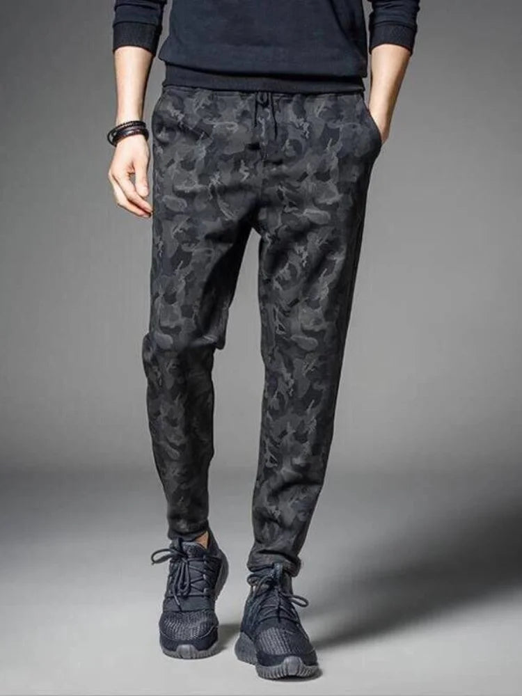 Men's camouflage elastic waist drawstring pants shown on a model.