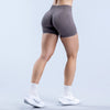 A person wearing seamless high-waisted yoga shorts in a gray color standing and posing.