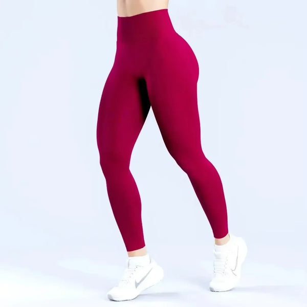 A model wearing seamless high-waist yoga leggings in a deep magenta color.