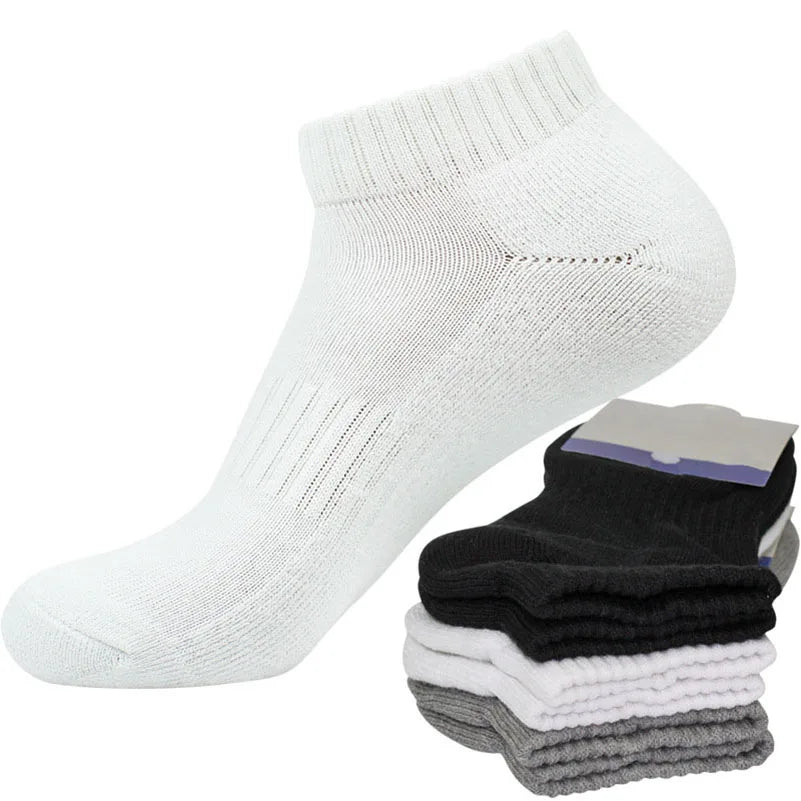 Una pila de tres calcetines deportivos blancos de algodón para hombre y mujer