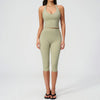 A woman wearing a light olive green women's premium fitness tracksuit top and leggings.