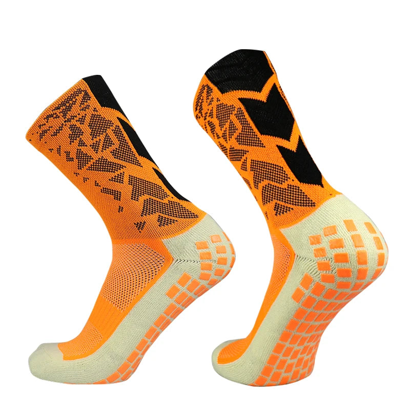 A pair of bright orange and white anti-slip training socks for sports, shown from the side.