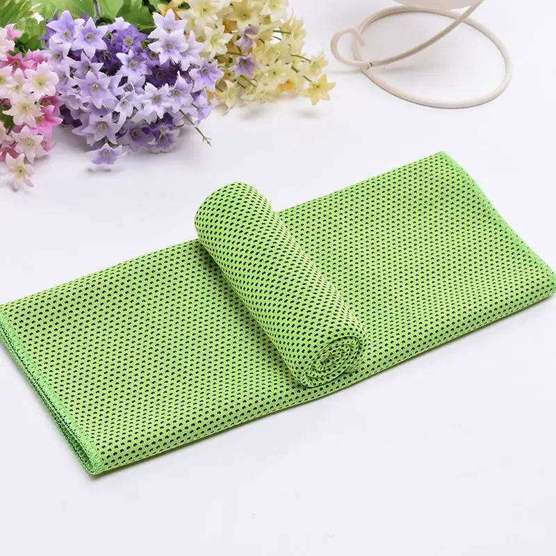 Serviette de refroidissement circulaire vert vif, roulée sur fond blanc avec des fleurs violettes et jaunes.