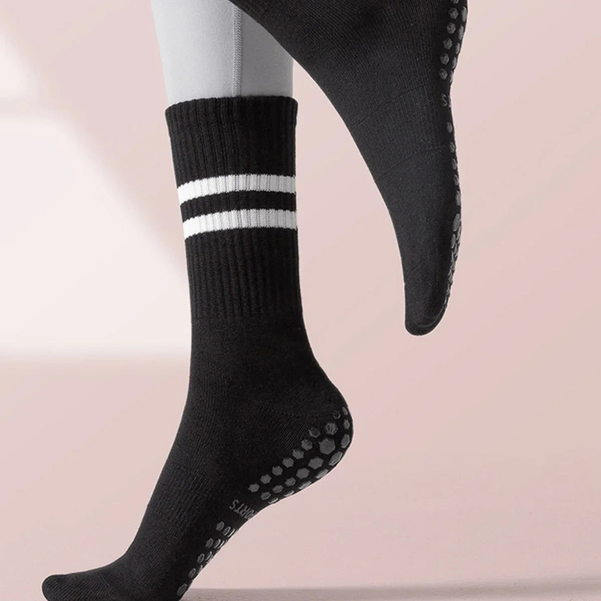 Black grip socks with white stripes on a person's foot