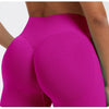 A close-up shot of a woman wearing bright magenta seamless high-waist yoga leggings.