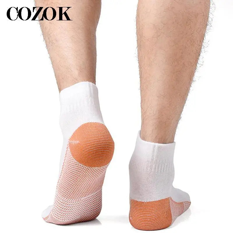 Paires de chaussettes de compression en fibre de cuivre beige et blanc portées sur la jambe d'une personne.