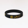 Black silicone wristband with gold embossed number 10 and initials on a white background.