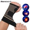 A hand wearing a black copper fiber wrist bracer for fitness and sport.