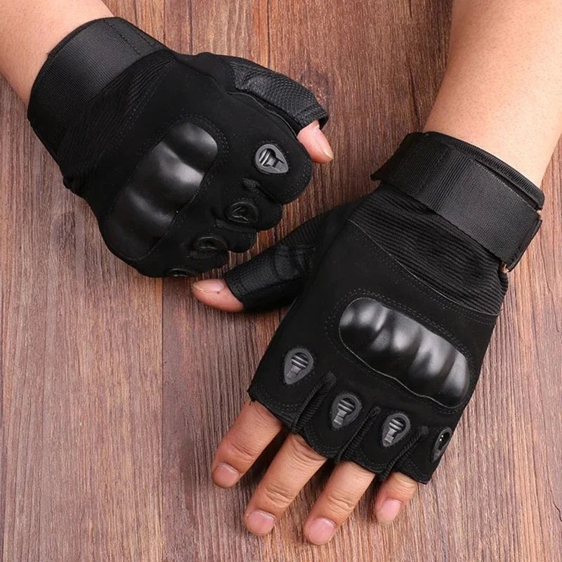Black half finger tactical gloves worn on a hand against a wooden background.