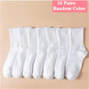 Ten pairs of random colored white socks laid out in a row.