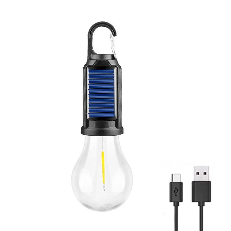 A black solar rechargeable camping lantern with a clear bulb and a metal handle.