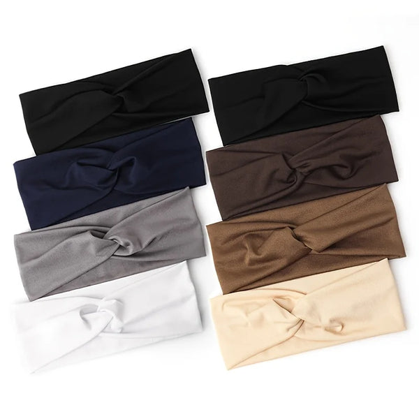 A collection of knotted elastic sports headbands in black, navy blue, gray, brown, and cream.