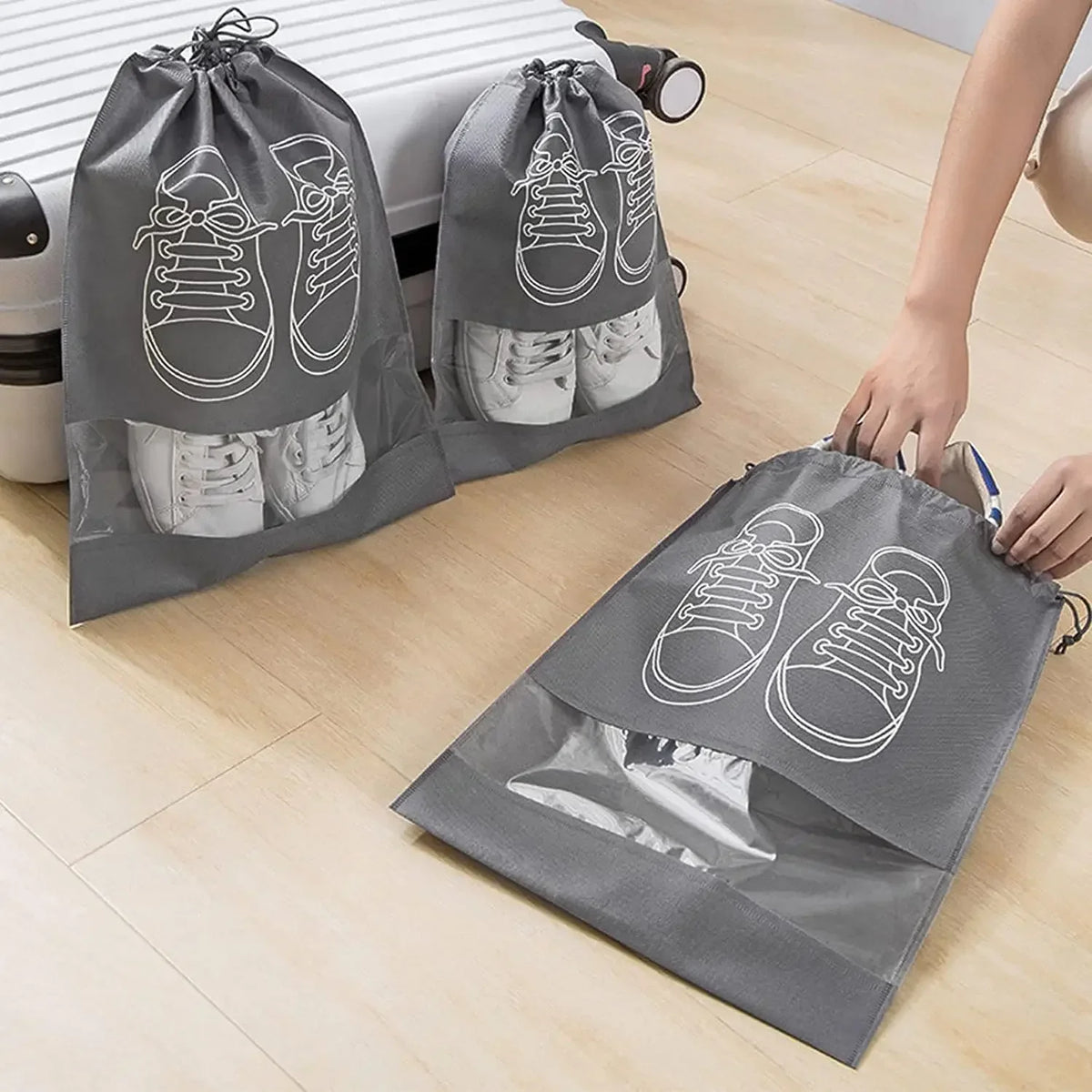 Gray reusable non-woven shoe storage bags filled with sneakers and boots