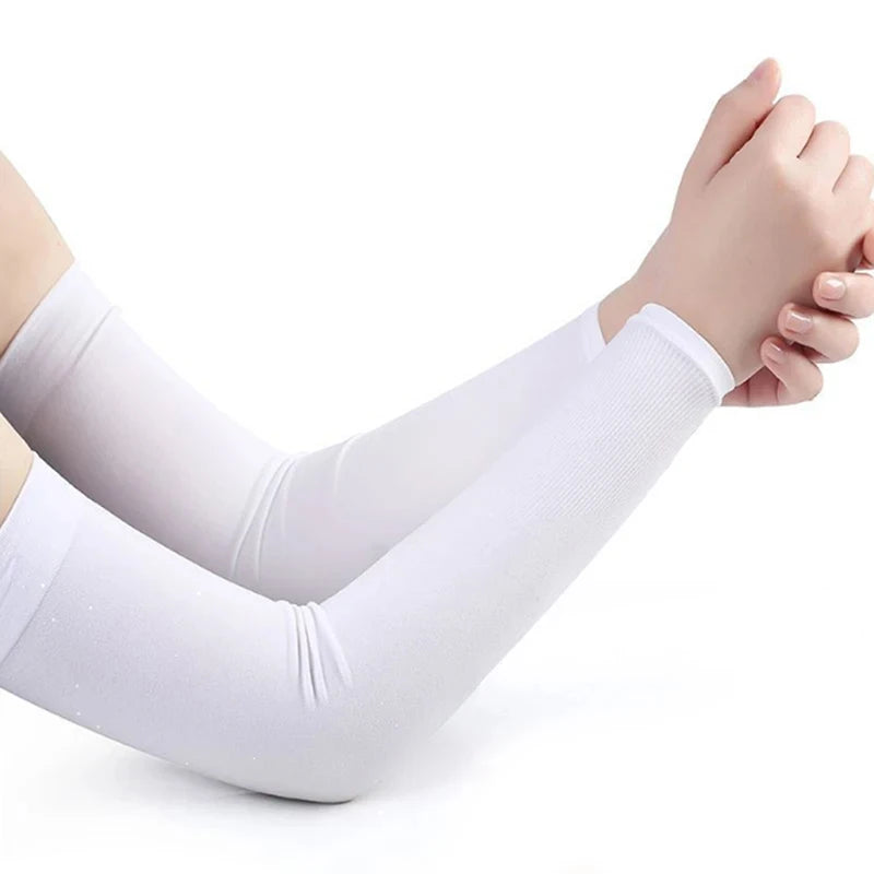White compression arm sleeves being worn on a person's arms.