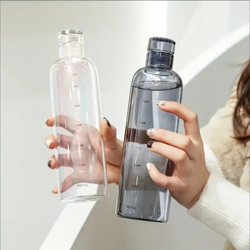A person holds a clear, elegant leakproof insulated water bottle with a time scale markings.