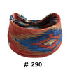 A close-up of a reddish-orange boho cotton turban headband with blue and gold geometric patterns.