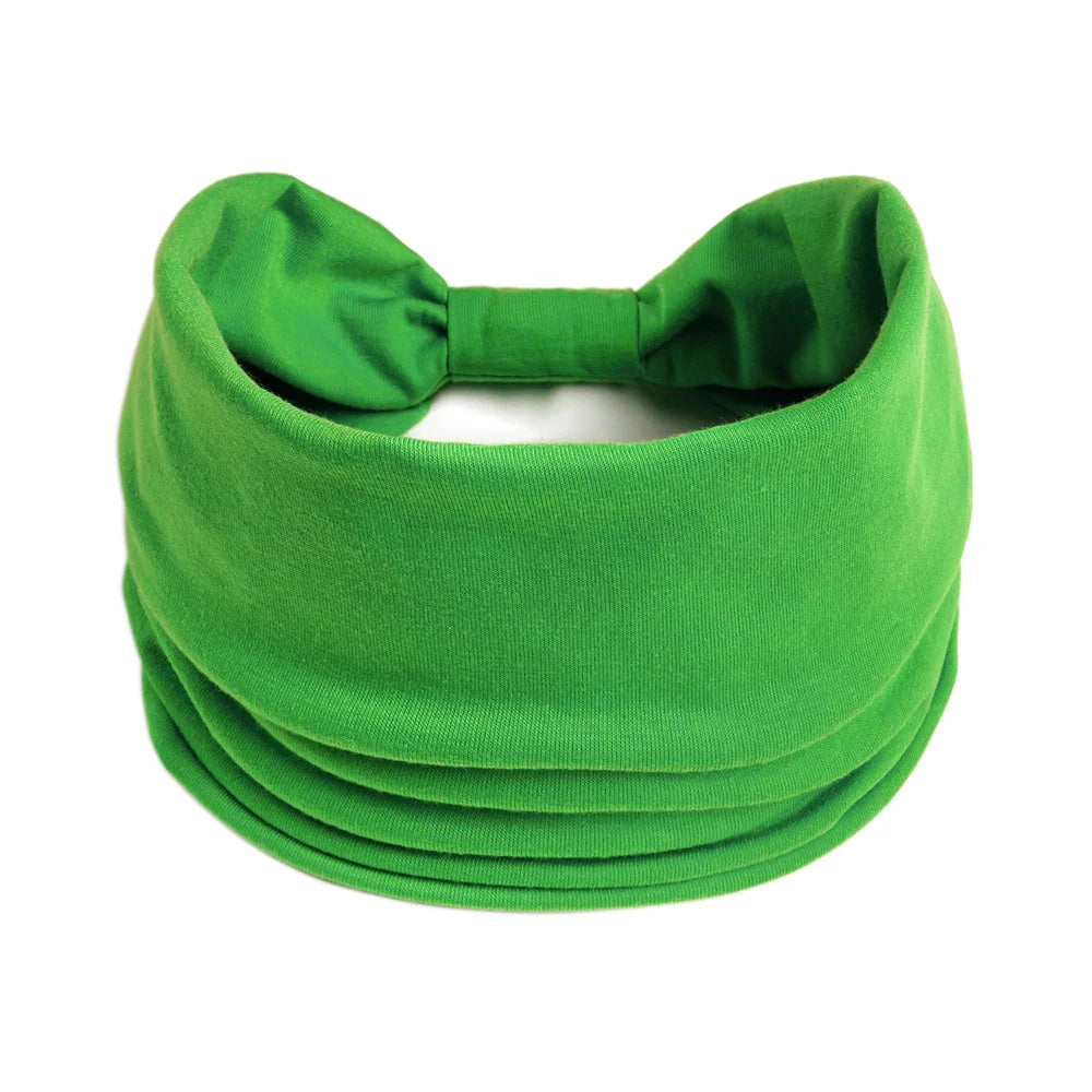 Un foulard de tissu vert vif noué en nœud, montré à plat.