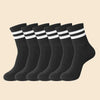 Eine Reihe schwarzer, gestreifter, atmungsaktiver Herrensocken liegen flach auf einem hellen Hintergrund.