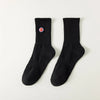 A pair of black men's athletic crew socks with a red and white embroidered logo on the heel.